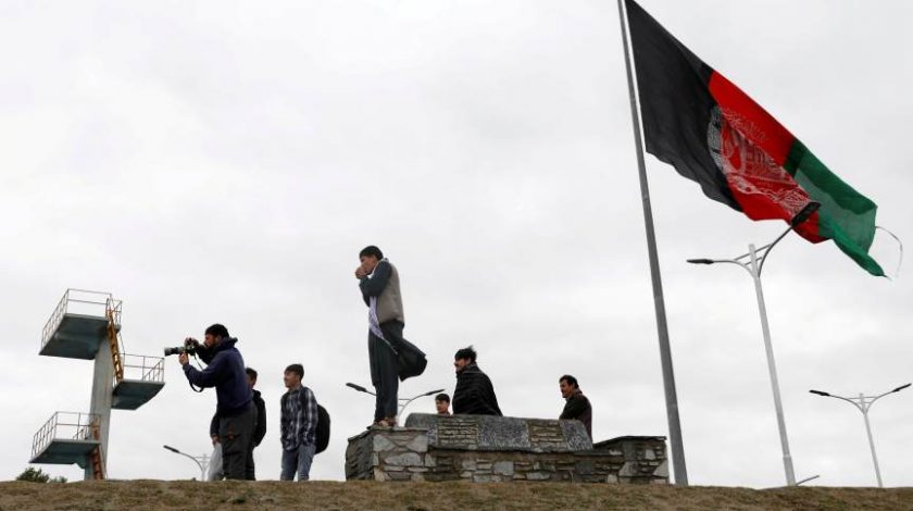 Foto: Pessoas tiram fotos ao lado da bandeira afegã em Cabul, Afeganistão
REUTERS