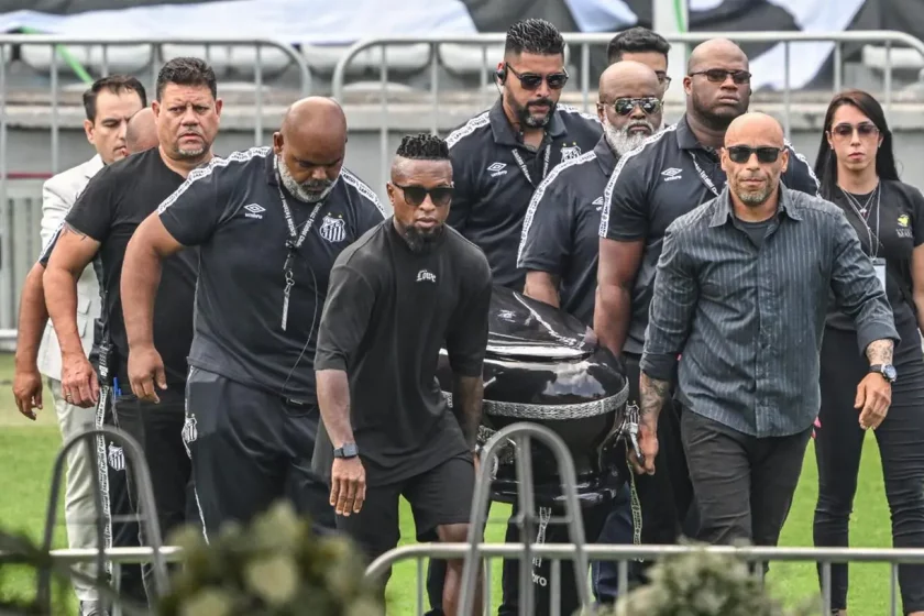 O ex-jogador Zé Roberto e o Edinho, filho do Rei, ajudam a levar o caixão com o corpo de Pelé para o centro do gramado, da Vila Belmiro, em Santos Foto: AFP