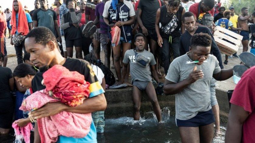 Imigrantes no Rio Grande, que divide a fronteira entre México e EUA, lavando as roupas Foto: GO NAKAMURA / REUTERS